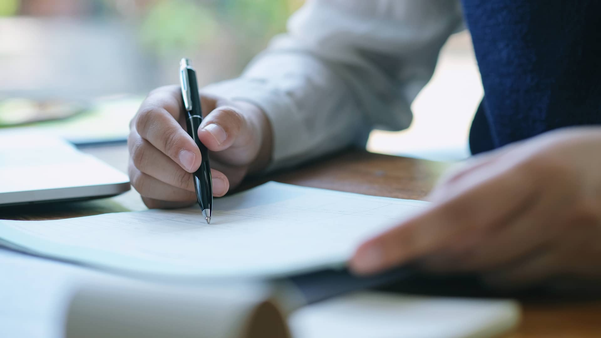 Hombre firmando papeles hipoteca sin aval Hombre firmando papeles hipoteca sin aval