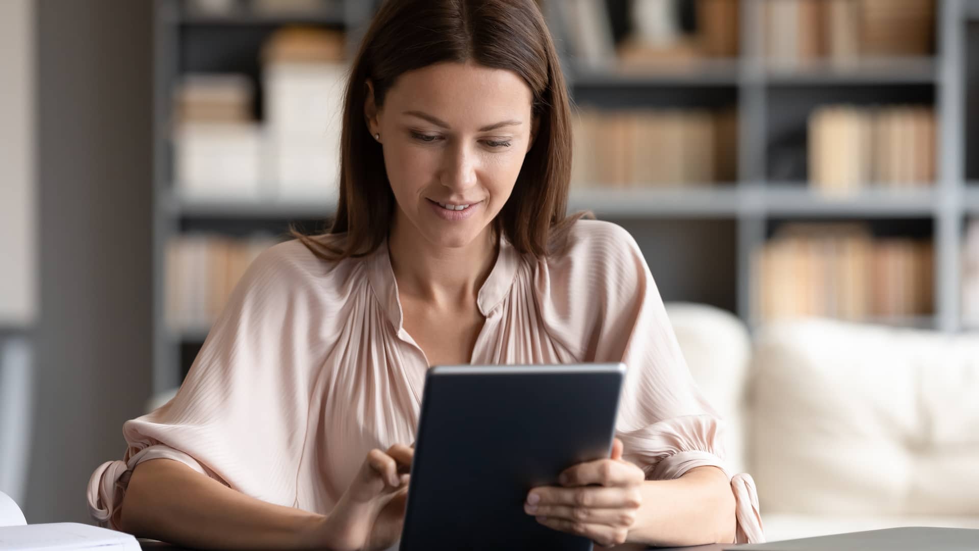 Mujer buscando en su tablet que es levantamiento de hipoteca Mujer buscando en su tablet que es levantamiento de hipoteca