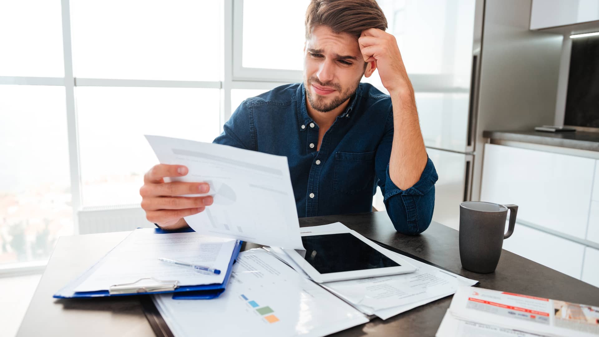 Joven preparando la documentacion necesaria para reclamar al banco los gastos de su hipoteca del bancoo popular