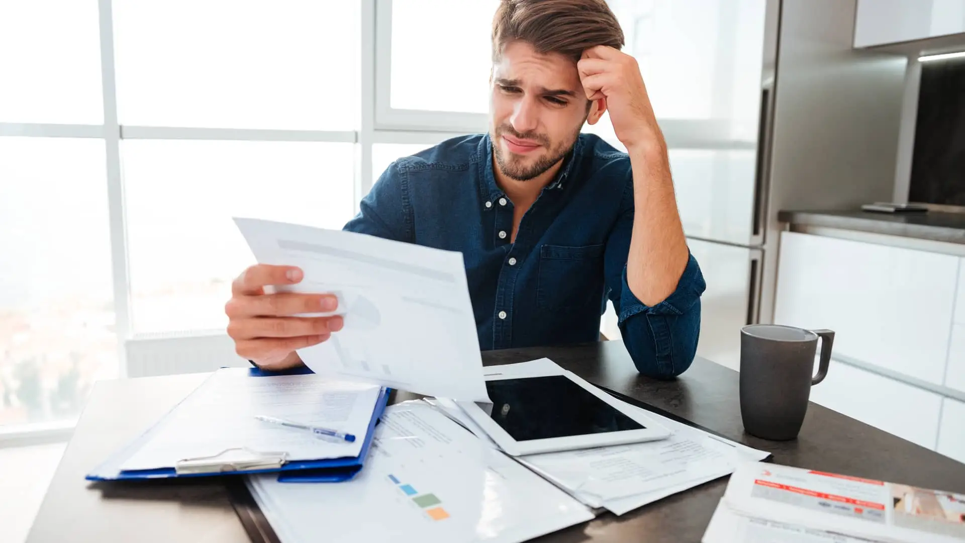 Joven preparando la documentacion necesaria para reclamar al banco los gastos de su hipoteca del bancoo popular Joven preparando la documentacion necesaria para reclamar al banco los gastos de su hipoteca del bancoo popular