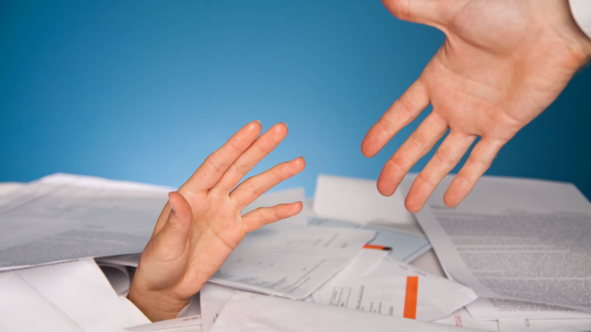 Persona sobrepasada por las deudas a la que la tienden la mano para reunificar su deuda Persona sobrepasada por las deudas a la que la tienden la mano para reunificar su deuda