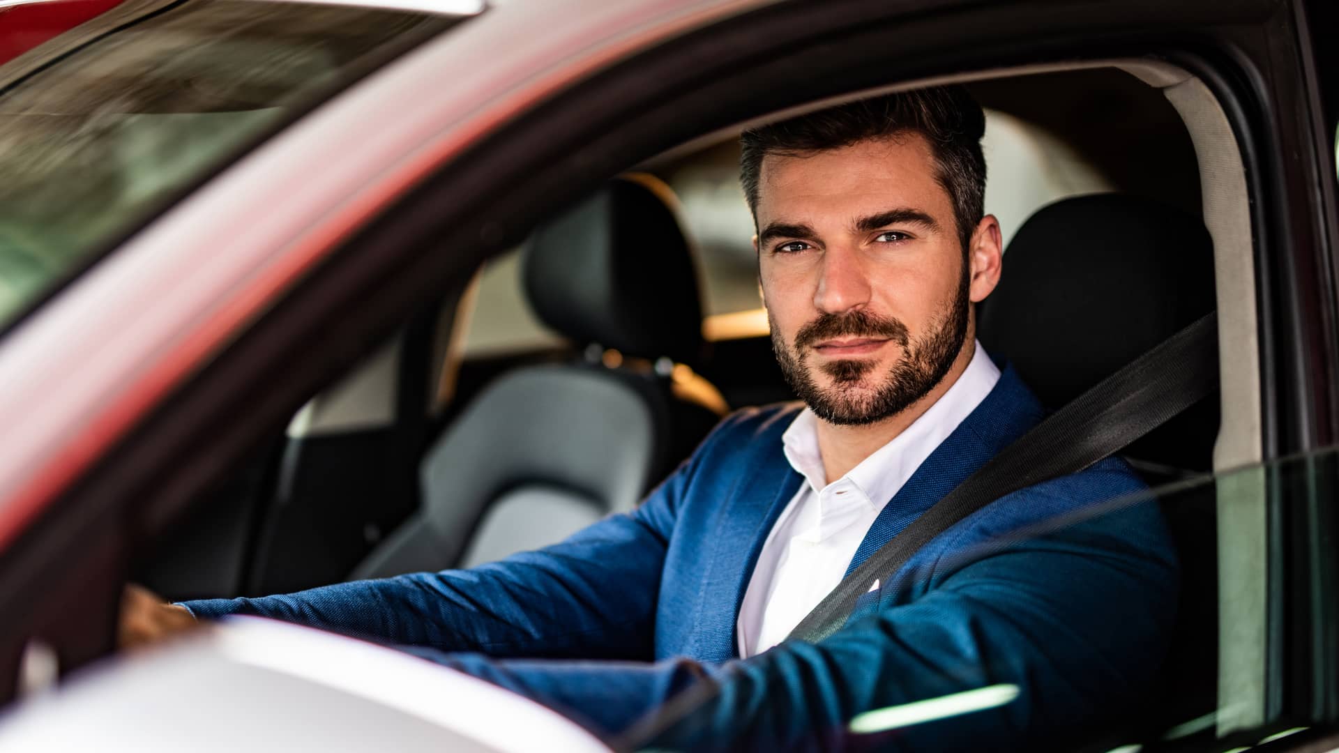 Hombre conduciendo su coche con seguro obligatorio