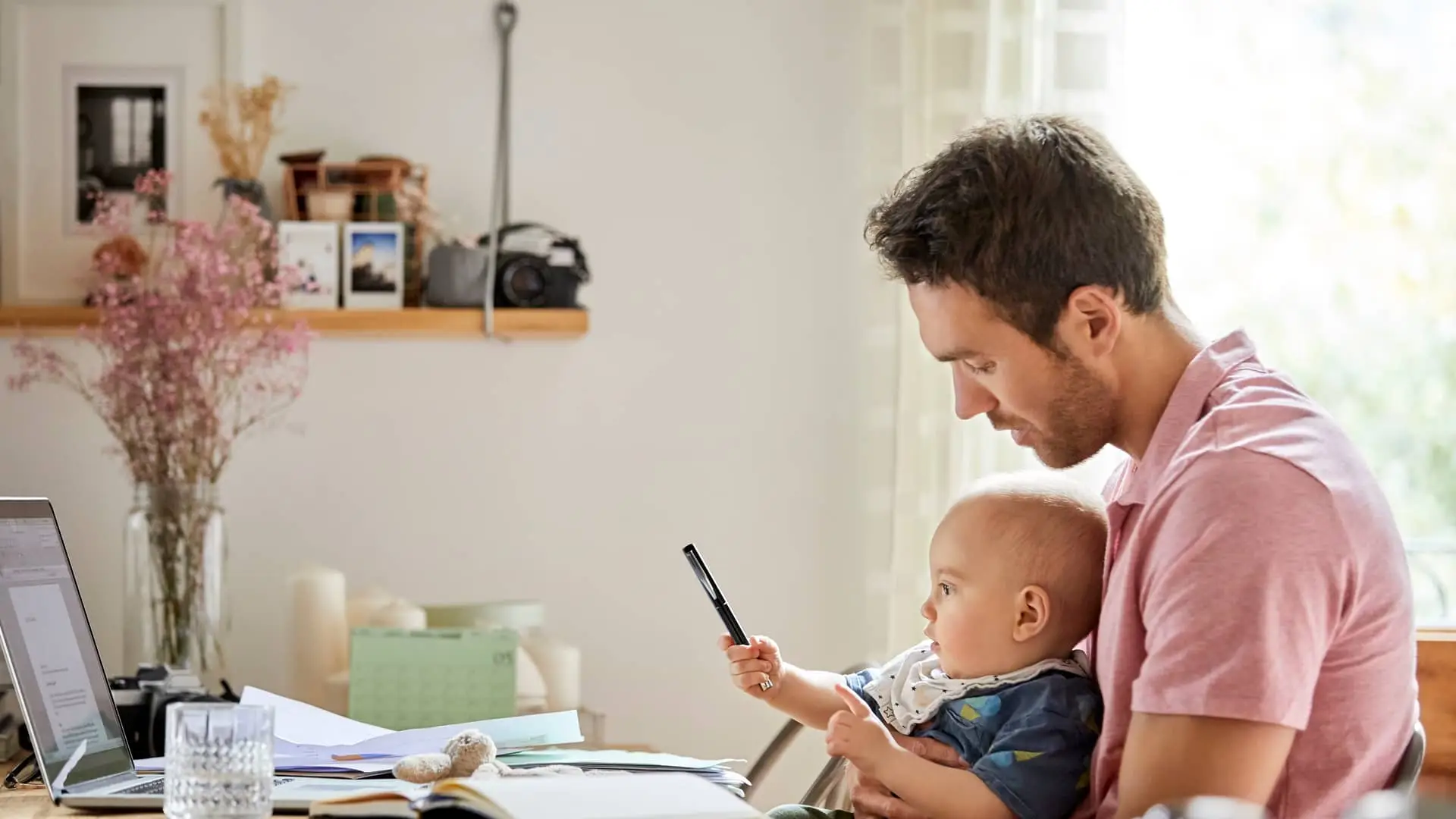 Hombre con bebé haciendo calculos de los gastos de subrogación Hombre con bebé haciendo calculos de los gastos de subrogación