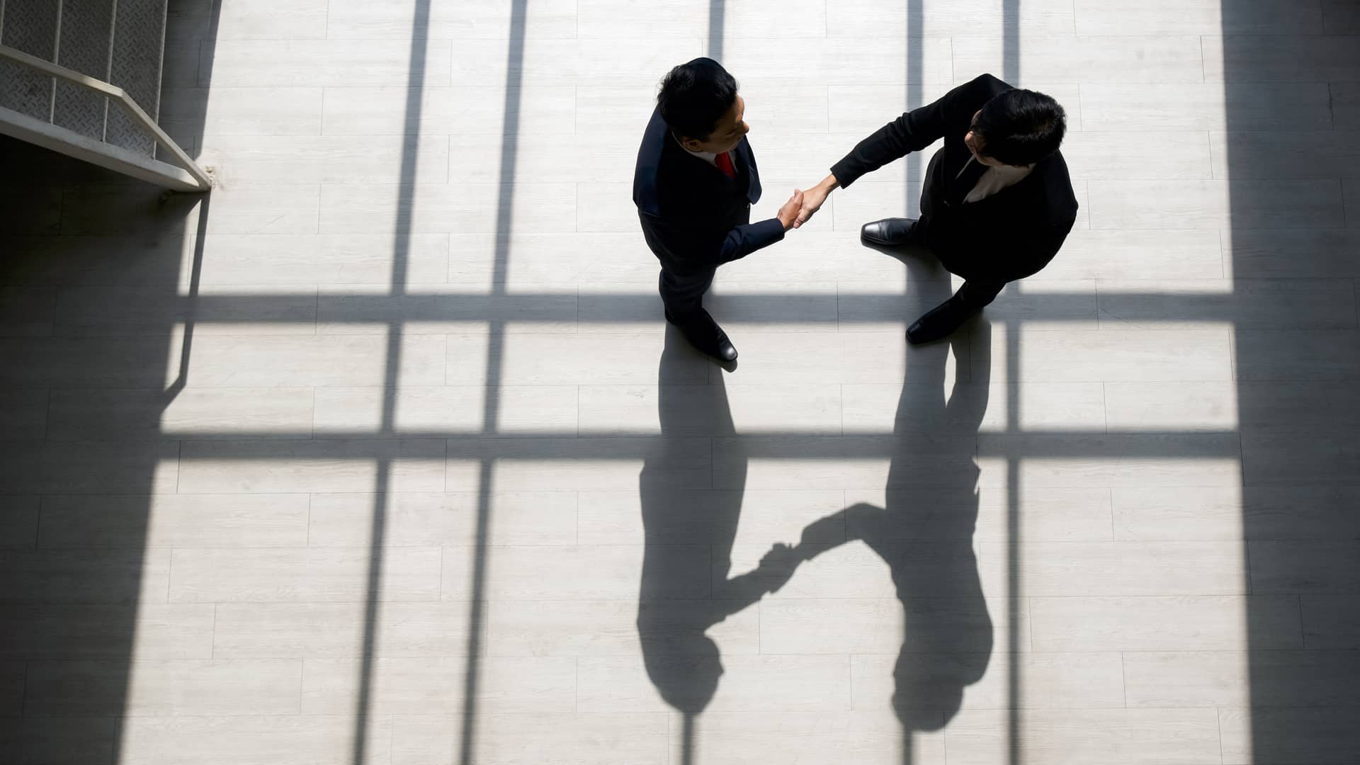 Hombres de negocios dandose la mano para cerrar acuerdo de subrogación de ampliación de capital
