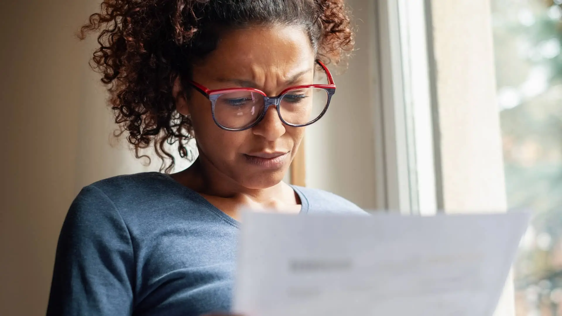 Mujer leyendo carta de embargo Mujer leyendo carta de embargo