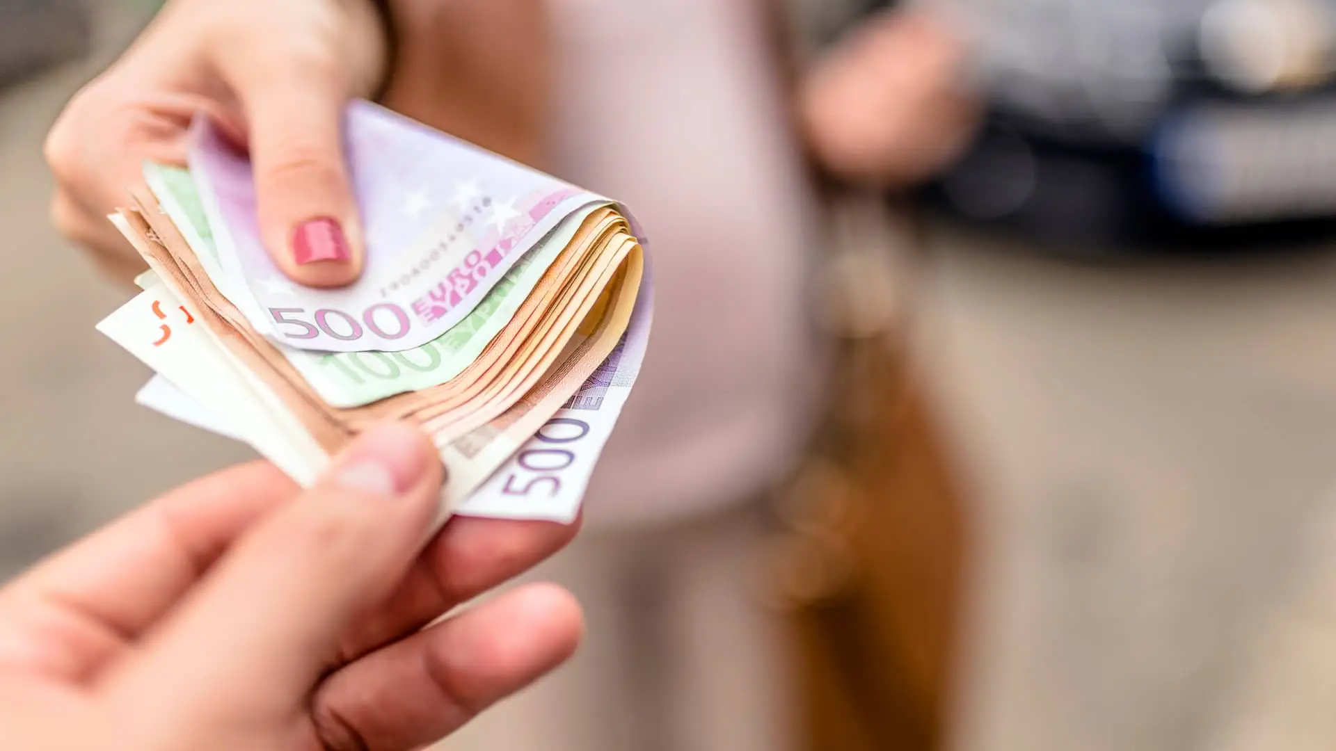 Mujer dando dinero a otra persona como traspaso de un plan de pensiones Mujer dando dinero a otra persona como traspaso de un plan de pensiones