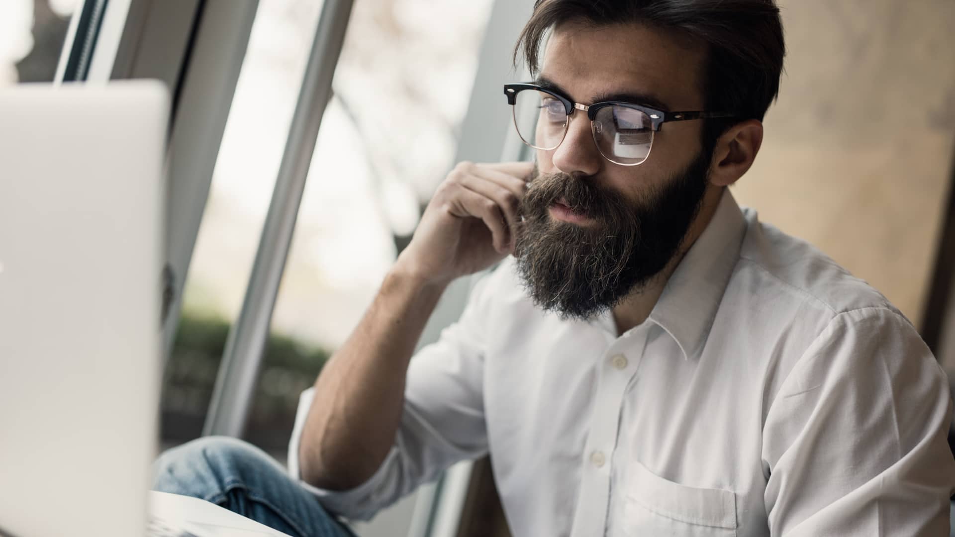 Hombre buscando en su ordenador como salir de la lista de morosos asnef