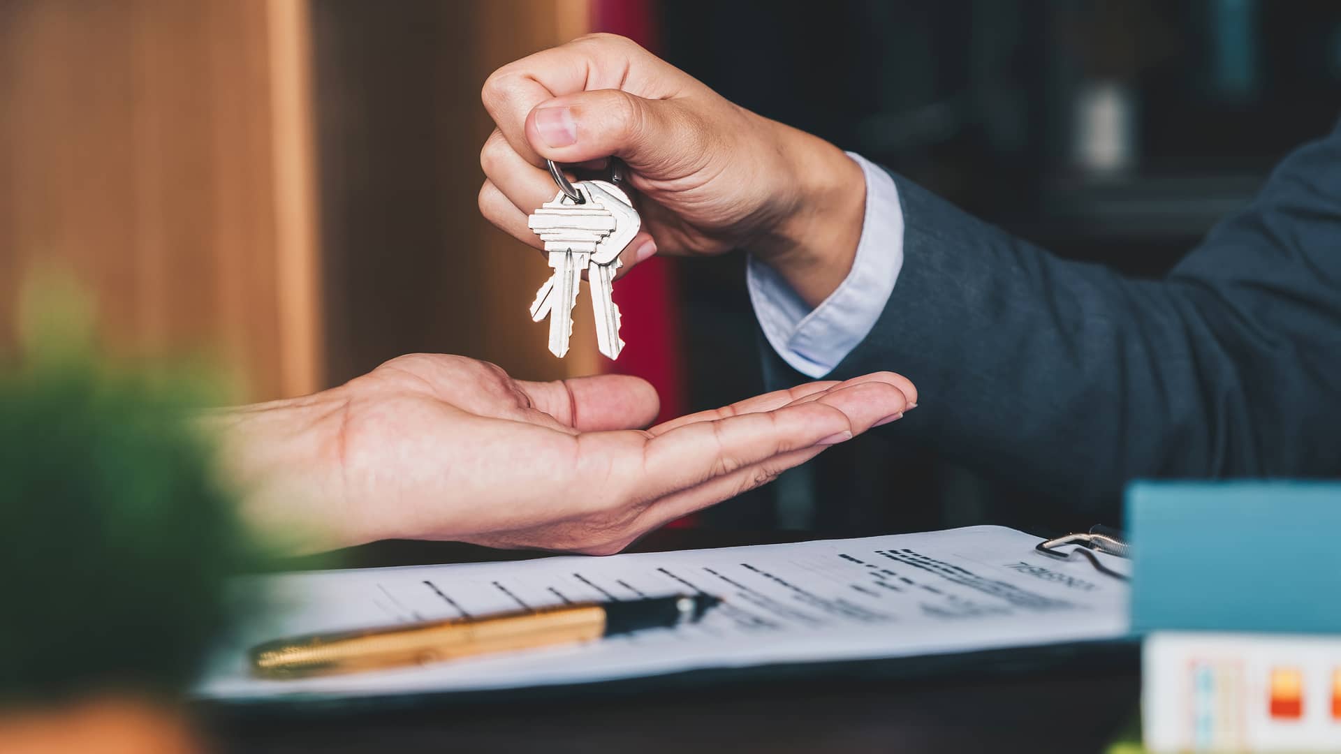 Mujer firmando papeles de compra de la casa sin necesidad de aval