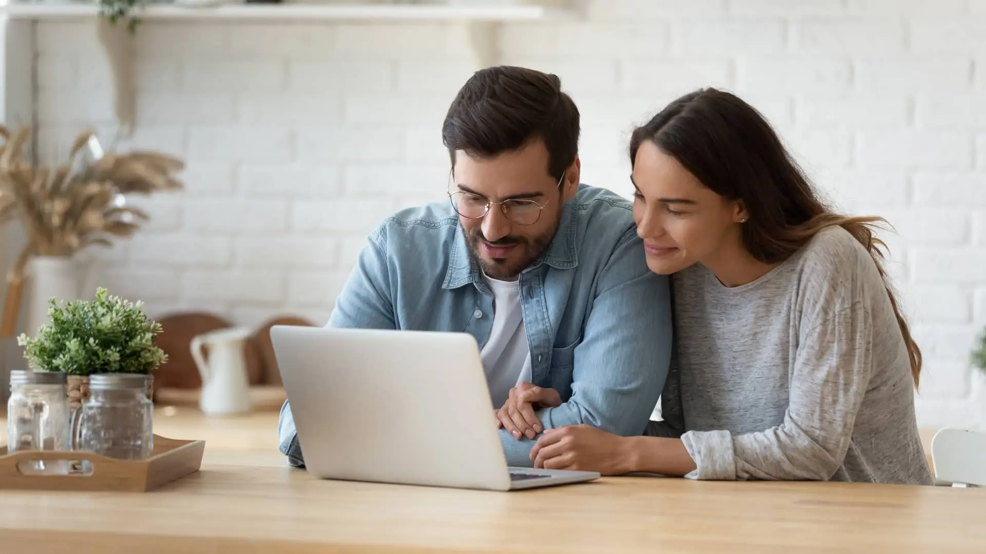 Pareja viendo en portátil los préstamos sín cambiar de banco Pareja viendo en portátil los préstamos sín cambiar de banco