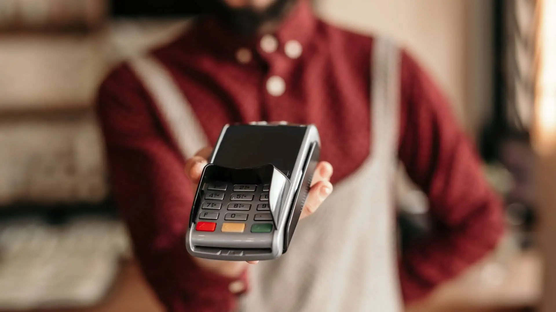 Joven ofreciendo datafono para realizar el pago con tarjeta contacless Joven ofreciendo datafono para realizar el pago con tarjeta contacless