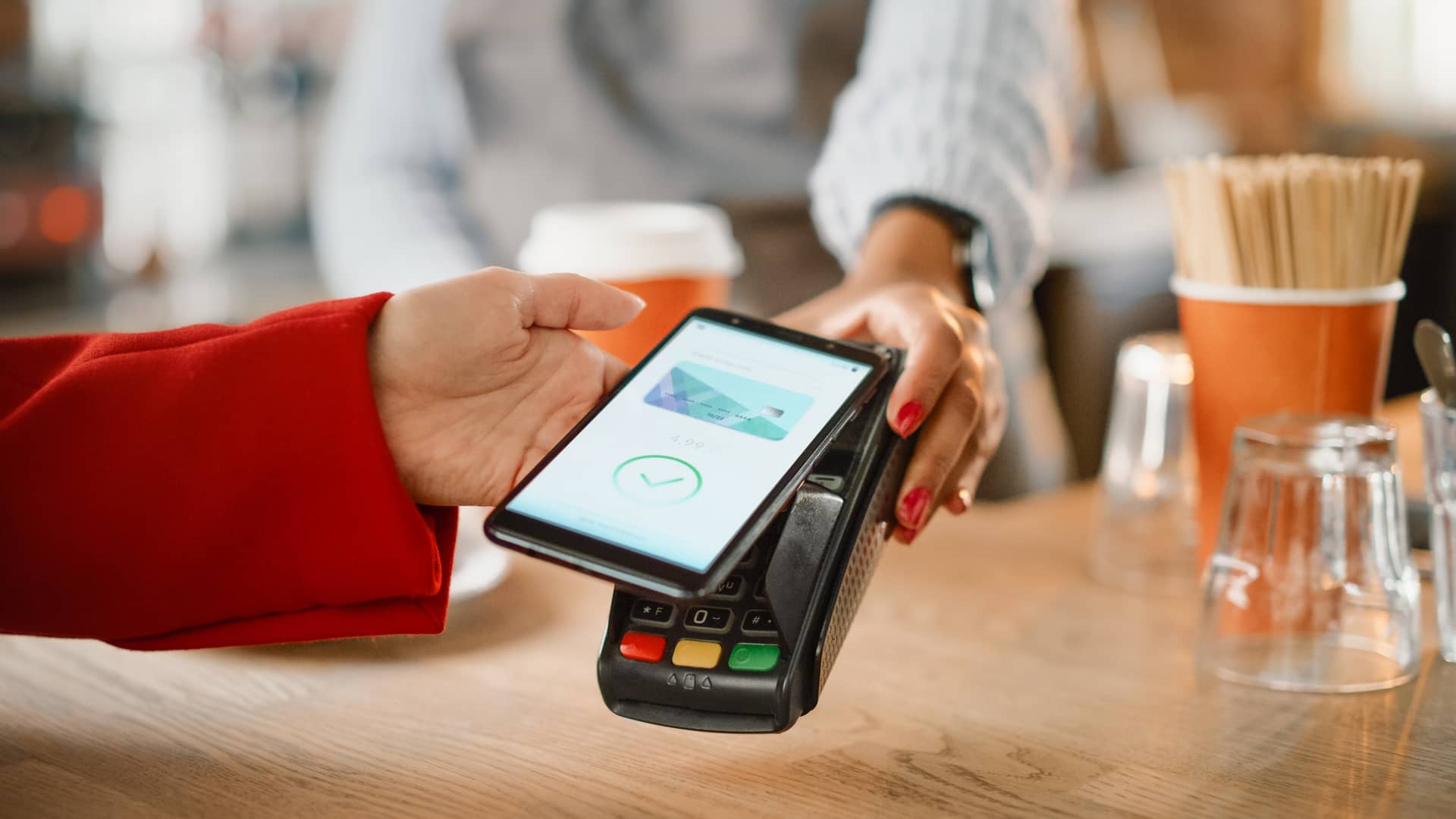 Mujer realizando pago con smartphone y recibiendo descuento de fidelización Mujer realizando pago con smartphone y recibiendo descuento de fidelización