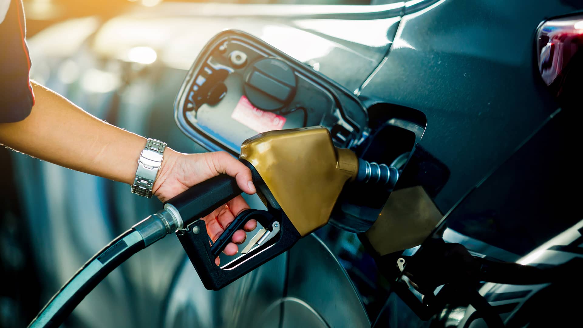 Joven repostando gasolina y pagando con tarjeta solred