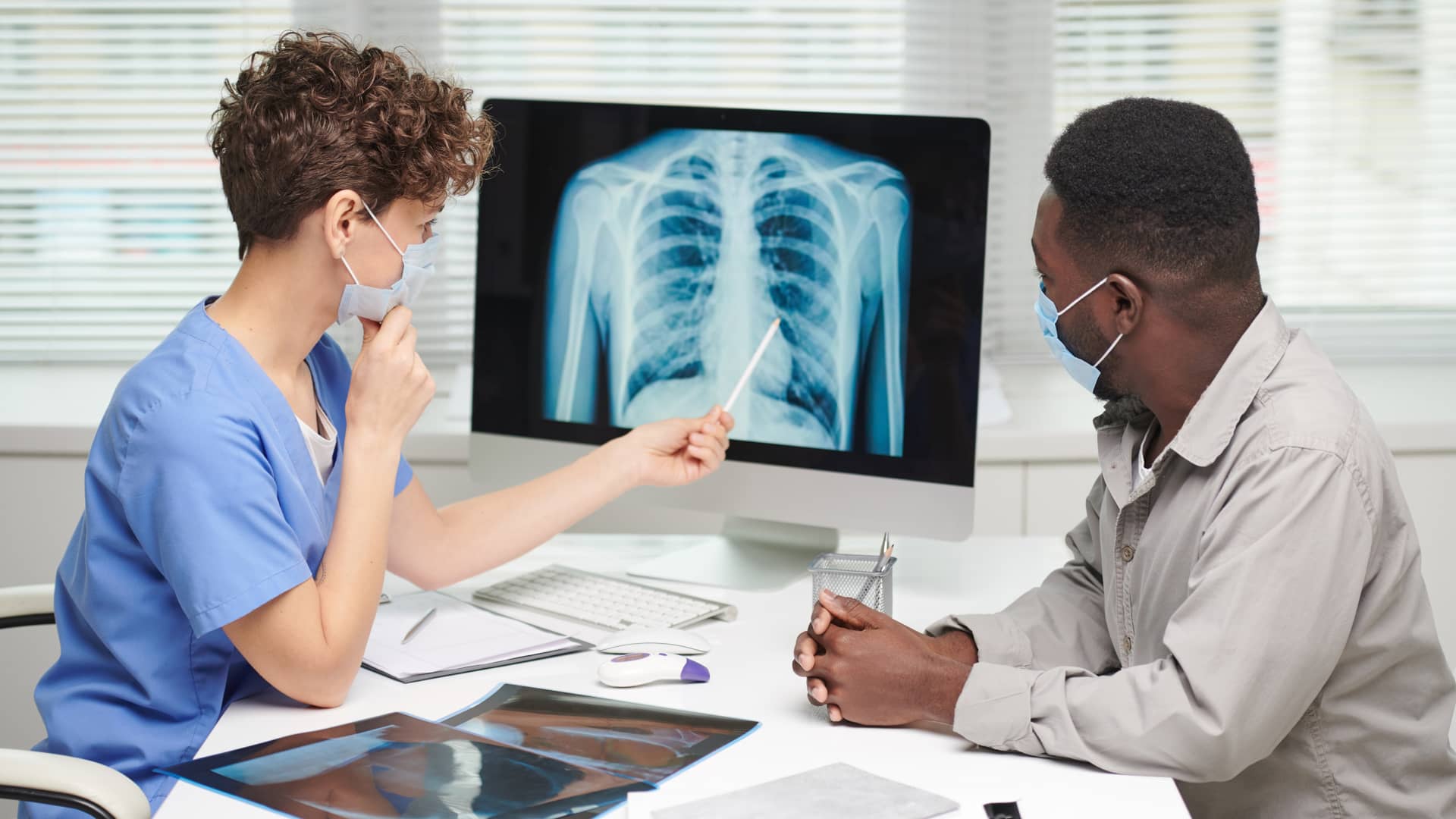 Médica neumóloga explica a su paciente asegurado con Adeslas los resultados de su radiografía pulmonar