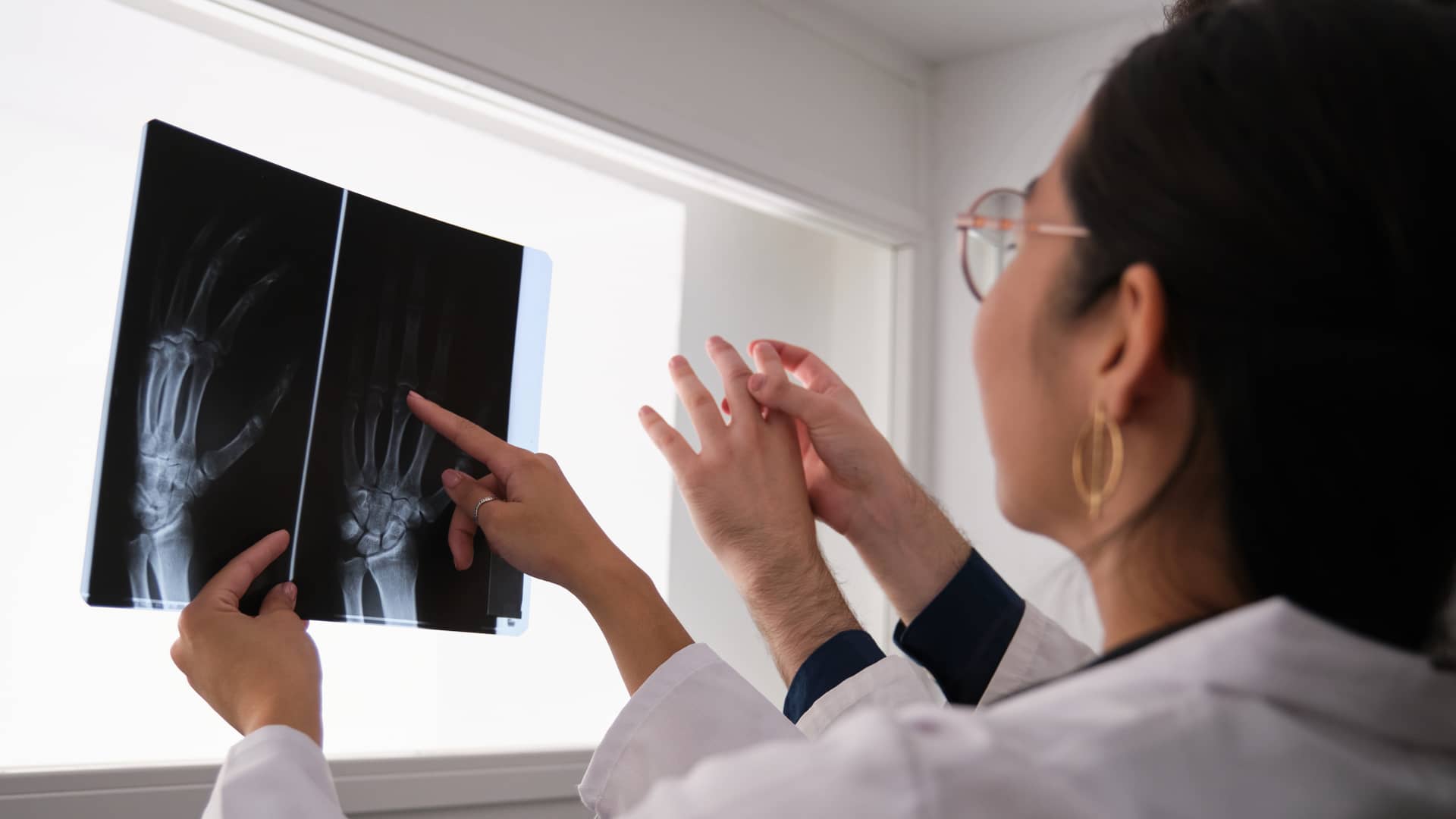 Médicos reumatólogo revisando las radiografías de un paciente asegurado por adeslas