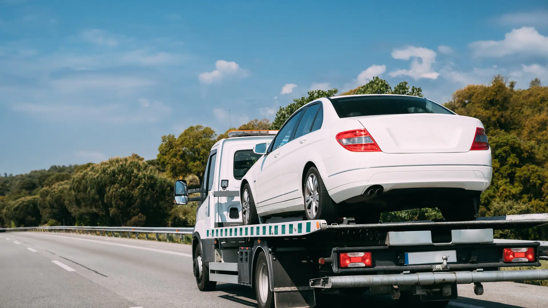 Una grúa llevandose un coche que tiene asistencia en carretera por un seguro de Allianz Direct