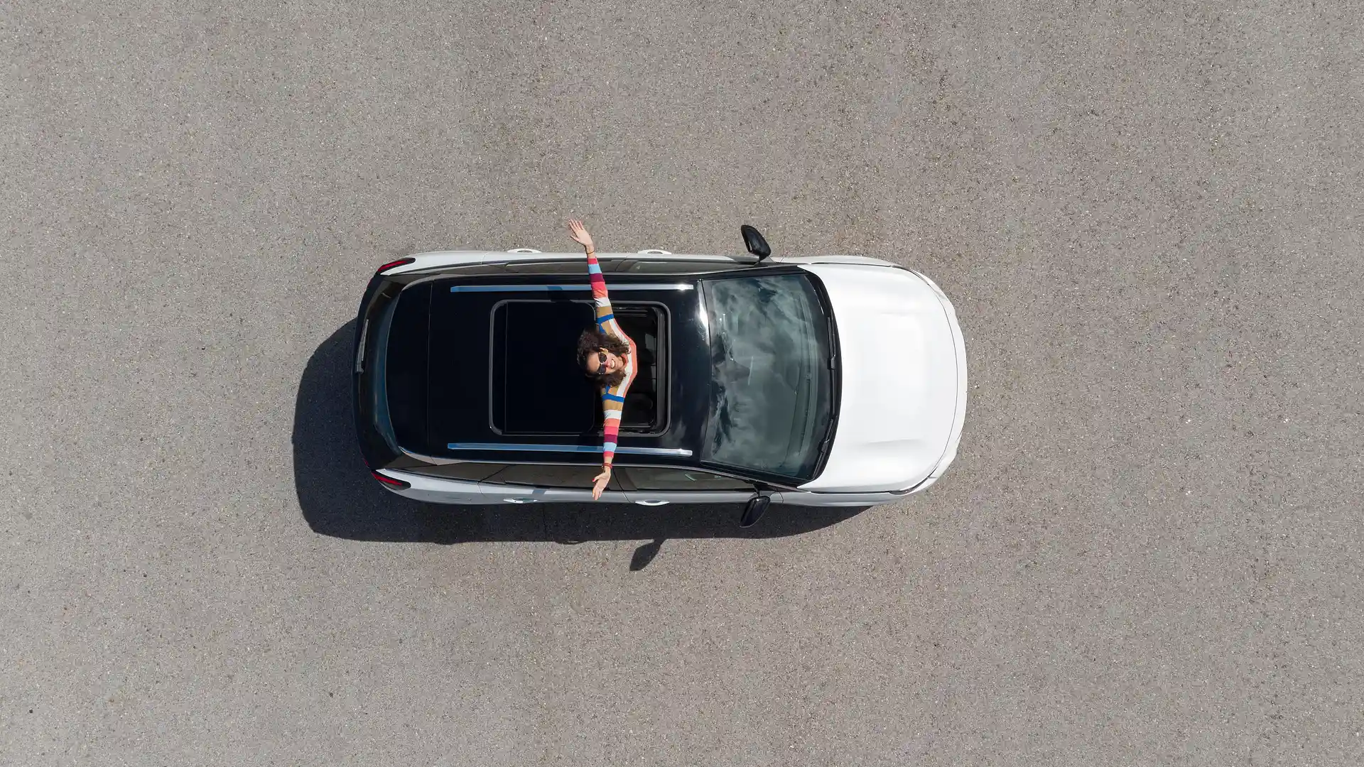 Vista de una mujer en su coche descapotable con un seguro de coche de Allianz Direct