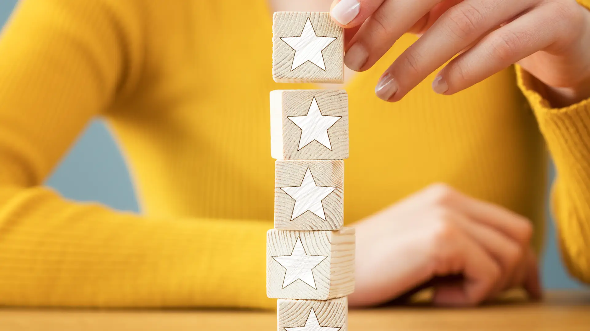 Mujer colocando dados con estrellas para dar su opinión sobre aseguradora allianz