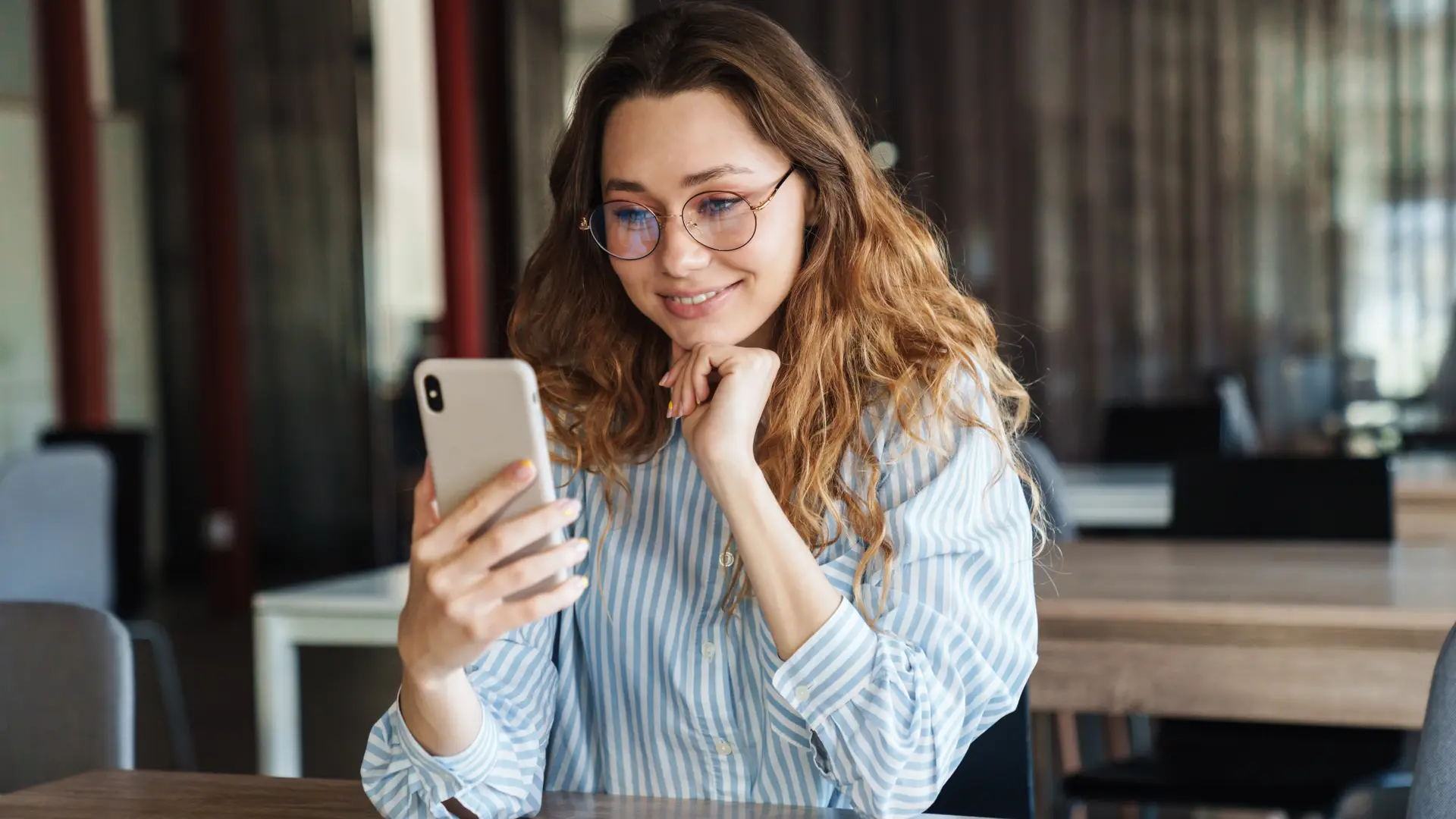 Una mujer con su telefono movil que va a pagar un recibo de la empresa Allianz desde la app