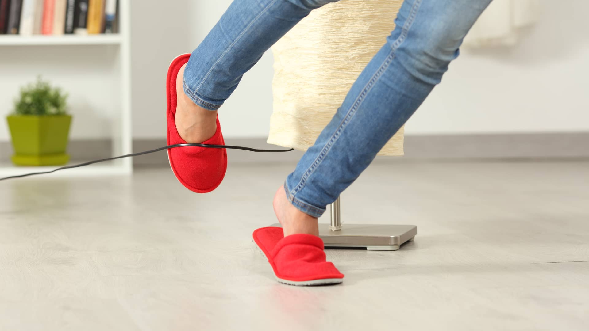 Mujer tropezando con cable de lámpara y con seguro de accidentes allianz conttratado Mujer tropezando con cable de lámpara y con seguro de accidentes allianz conttratado