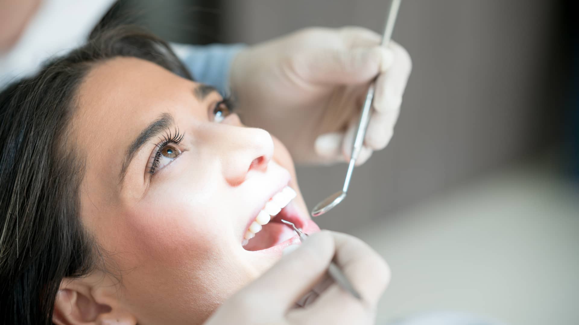 Mujer realizandose una revisión en su dentista con su seguro dental de allianz Mujer realizandose una revisión en su dentista con su seguro dental de allianz