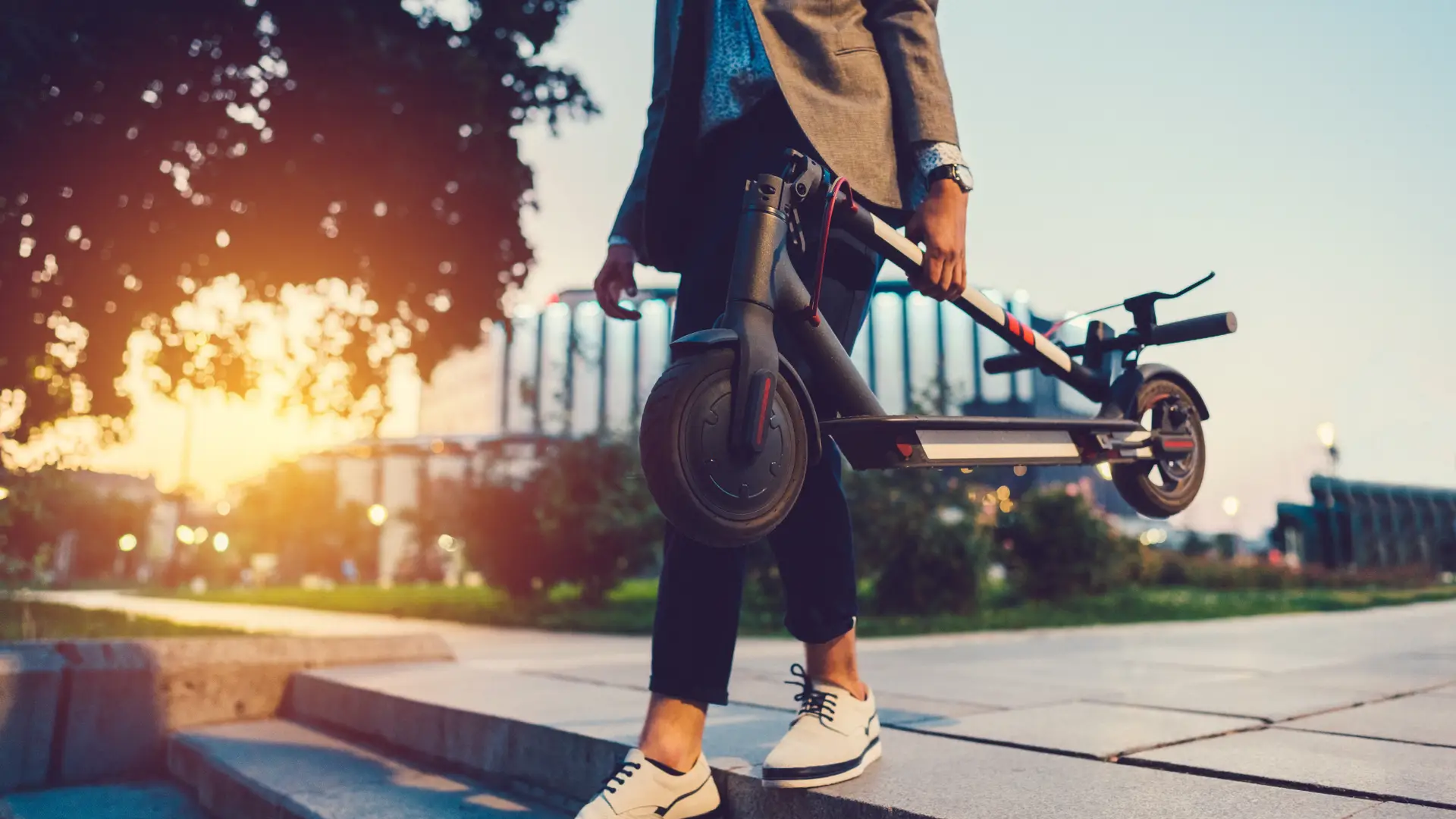 Hombre bajando escaleras con su patinete asegurado con allianz Hombre bajando escaleras con su patinete asegurado con allianz