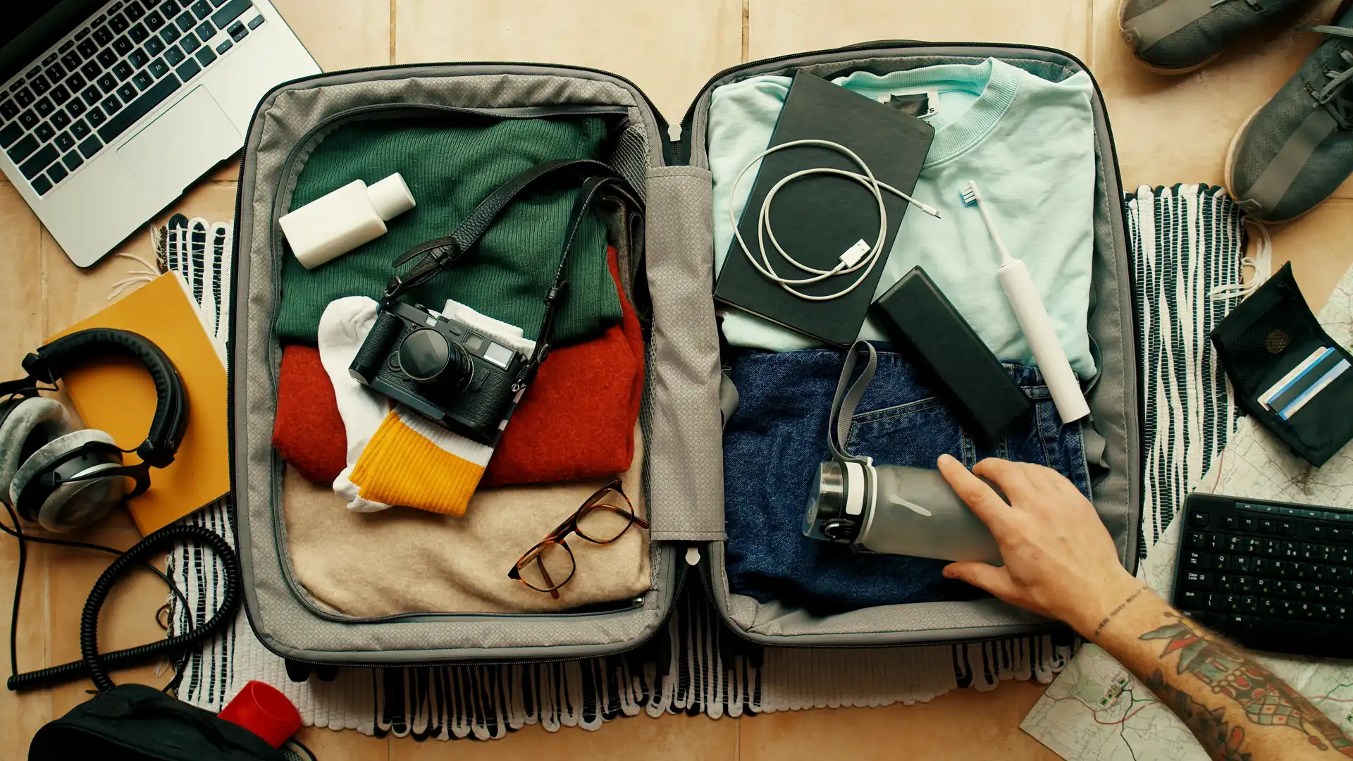 Persona preparando maleta para irse de vacaciones con seguro de viaje de ama contratado Persona preparando maleta para irse de vacaciones con seguro de viaje de ama contratado
