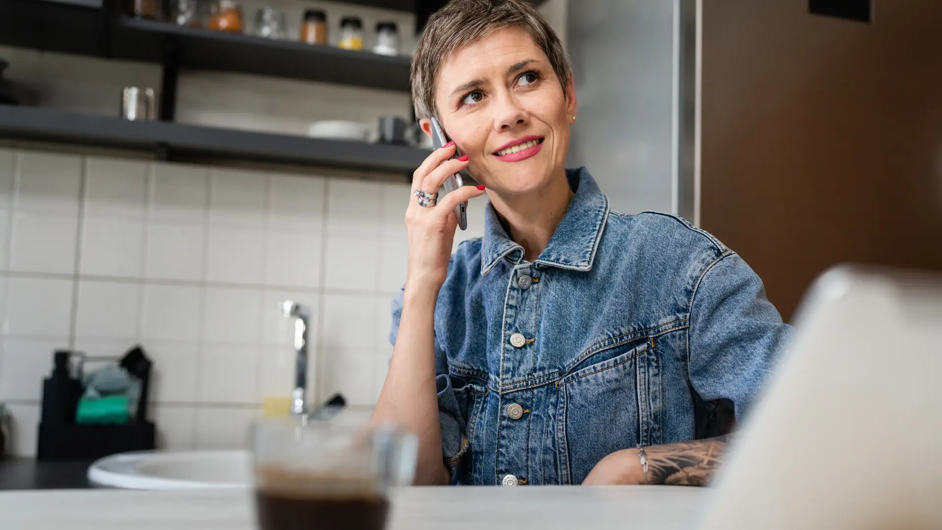 Una mujer en la cocina de su casa llamando por teléfono a la aseguradora ASC