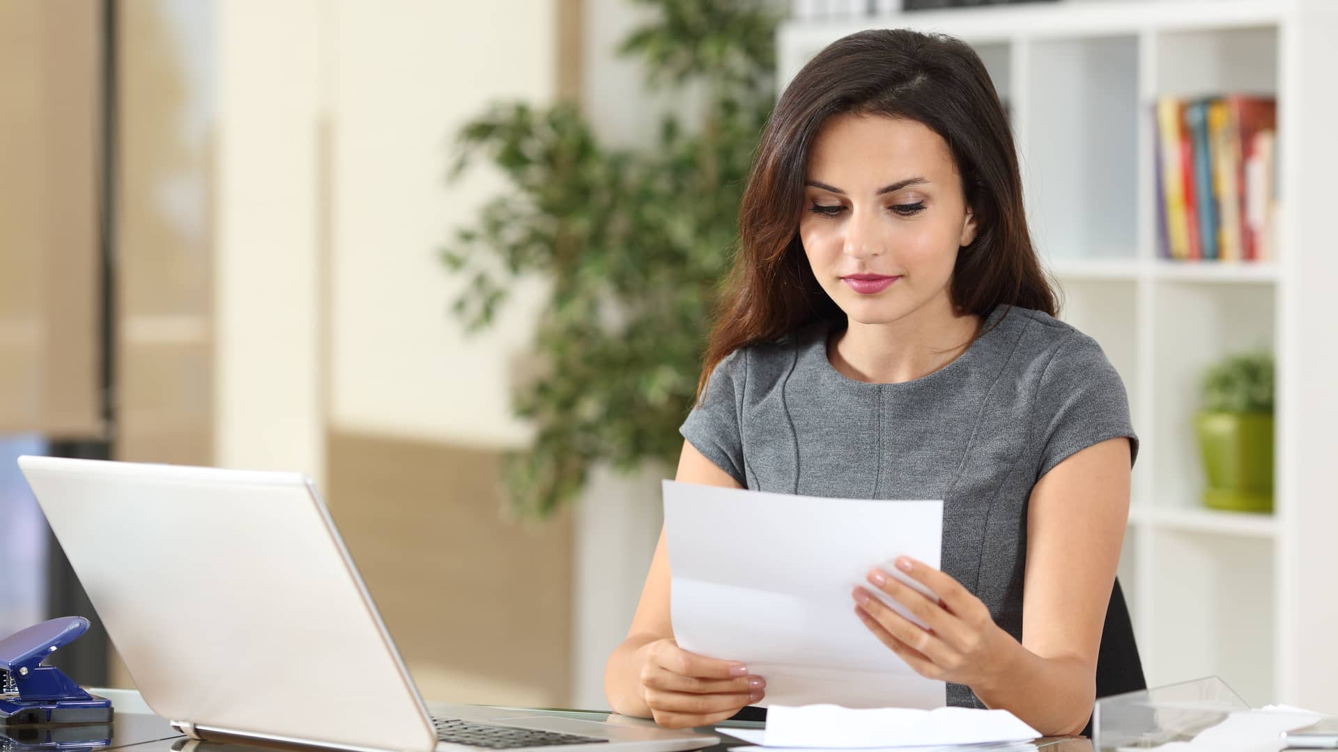 mujer con papeles y un ordenador consultando el precio de los distintos seguros de asisa mujer con papeles y un ordenador consultando el precio de los distintos seguros de asisa