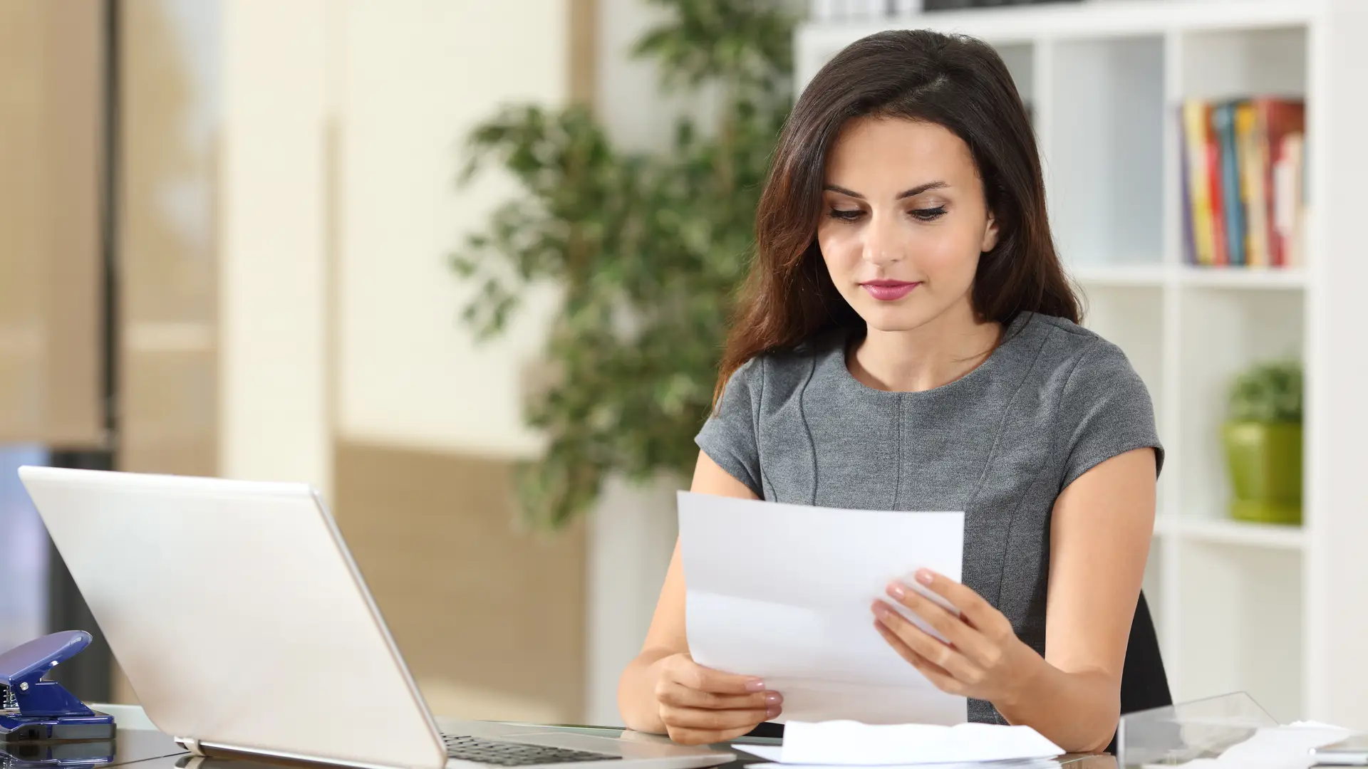 mujer con papeles y un ordenador consultando el precio de los distintos seguros de asisa mujer con papeles y un ordenador consultando el precio de los distintos seguros de asisa