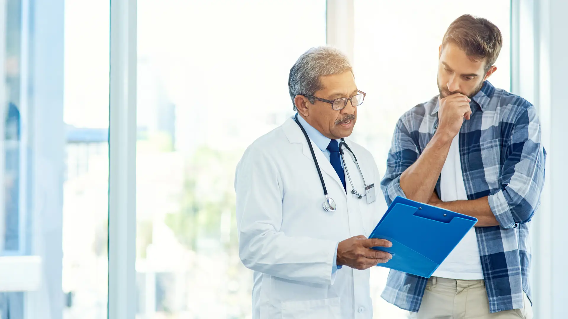 Hombre viendo resultado de las pruebas con médico de su seguro médico de asisa Hombre viendo resultado de las pruebas con médico de su seguro médico de asisa