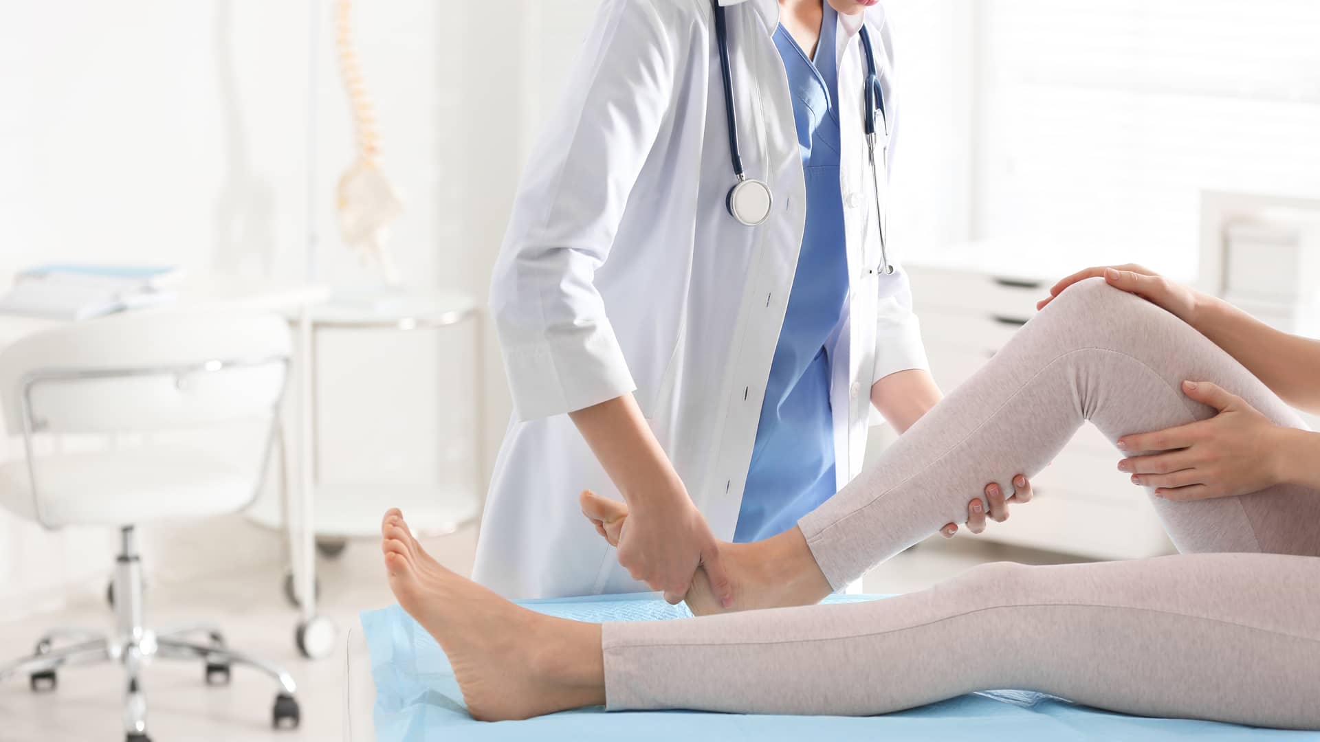 consulta de un medico traumatologo del cuadro medico de axa atendiendo los dolores de rodilla de una paciente