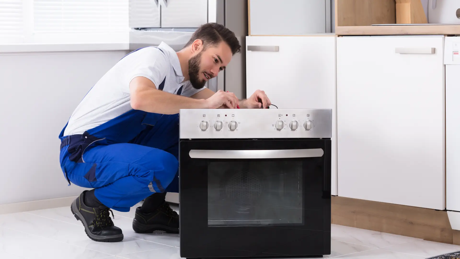 un manitas de la empresa axa arreglando el horno de un asrgurado  en su domiciio un manitas de la empresa axa arreglando el horno de un asrgurado  en su domiciio