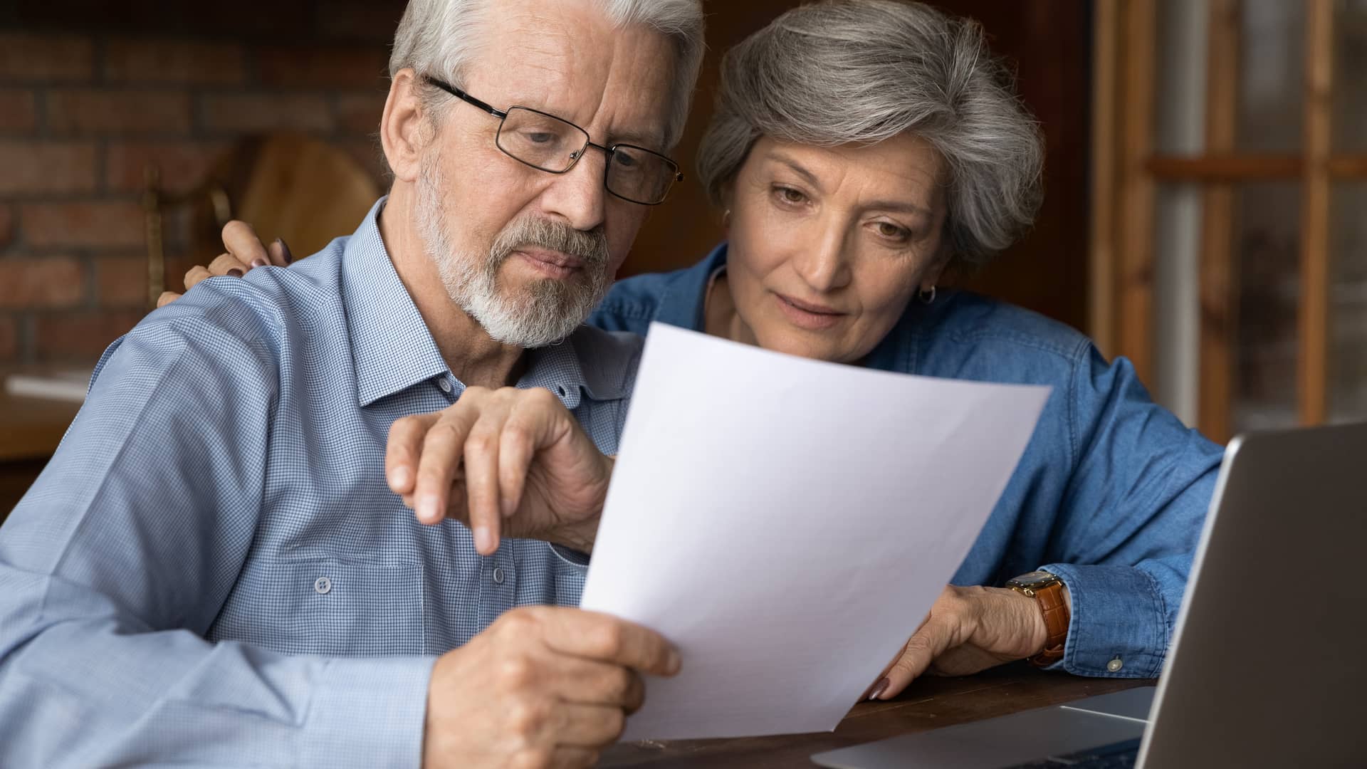 matrimonio anciano revisando los papeles de su plan de pensiones que va a gestionar con la aseguradora axa