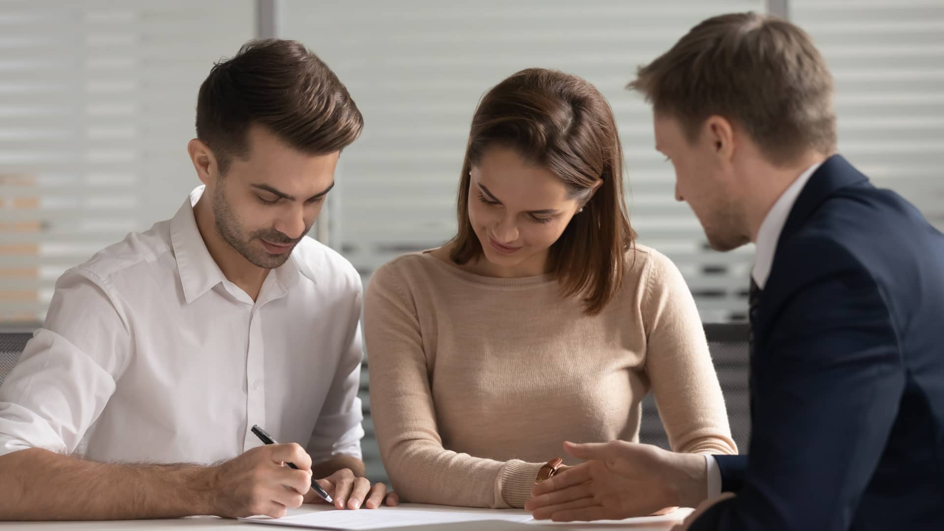 pareja joven firmando su nuevo seguro de arrendamiento de axa seguros