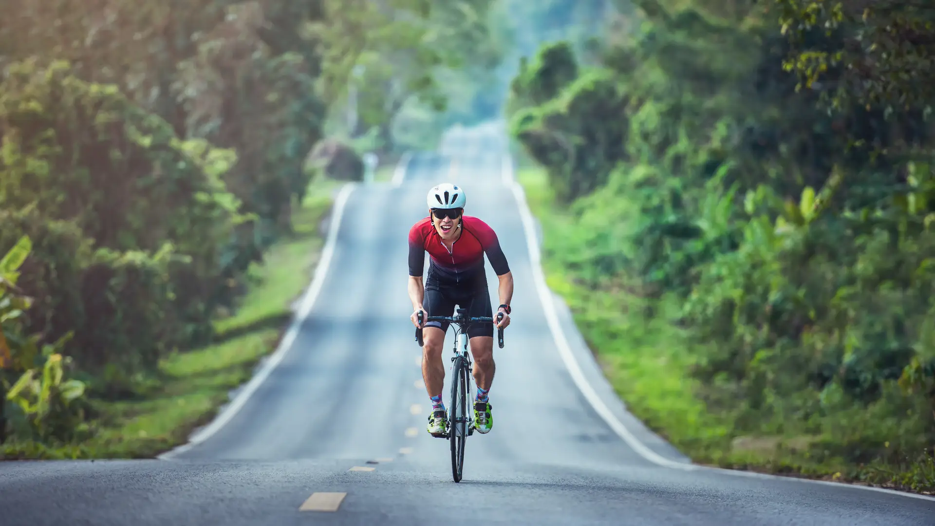 un hombre andando en bici por la carretera tranquilo porque tiene un seguro para deportistas de la aseguradora axa un hombre andando en bici por la carretera tranquilo porque tiene un seguro para deportistas de la aseguradora axa