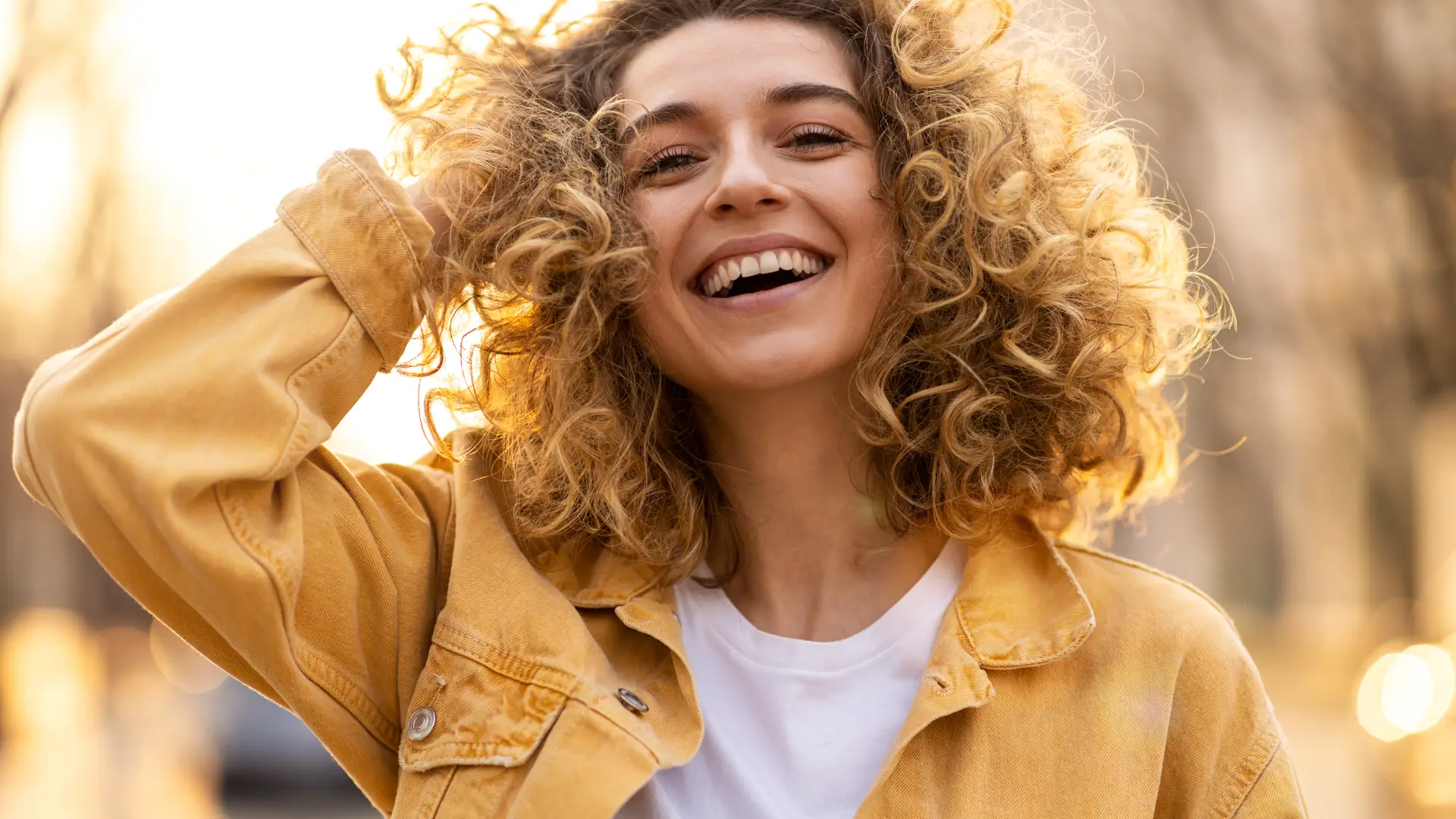 Mujer joven y sonriente con seguro de salud de axa óptima joven