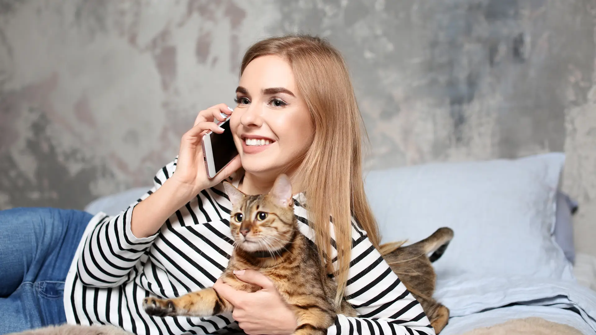 Una mujer hablando por teléfono con su gato a la aseguradora para mascotas Barkibu