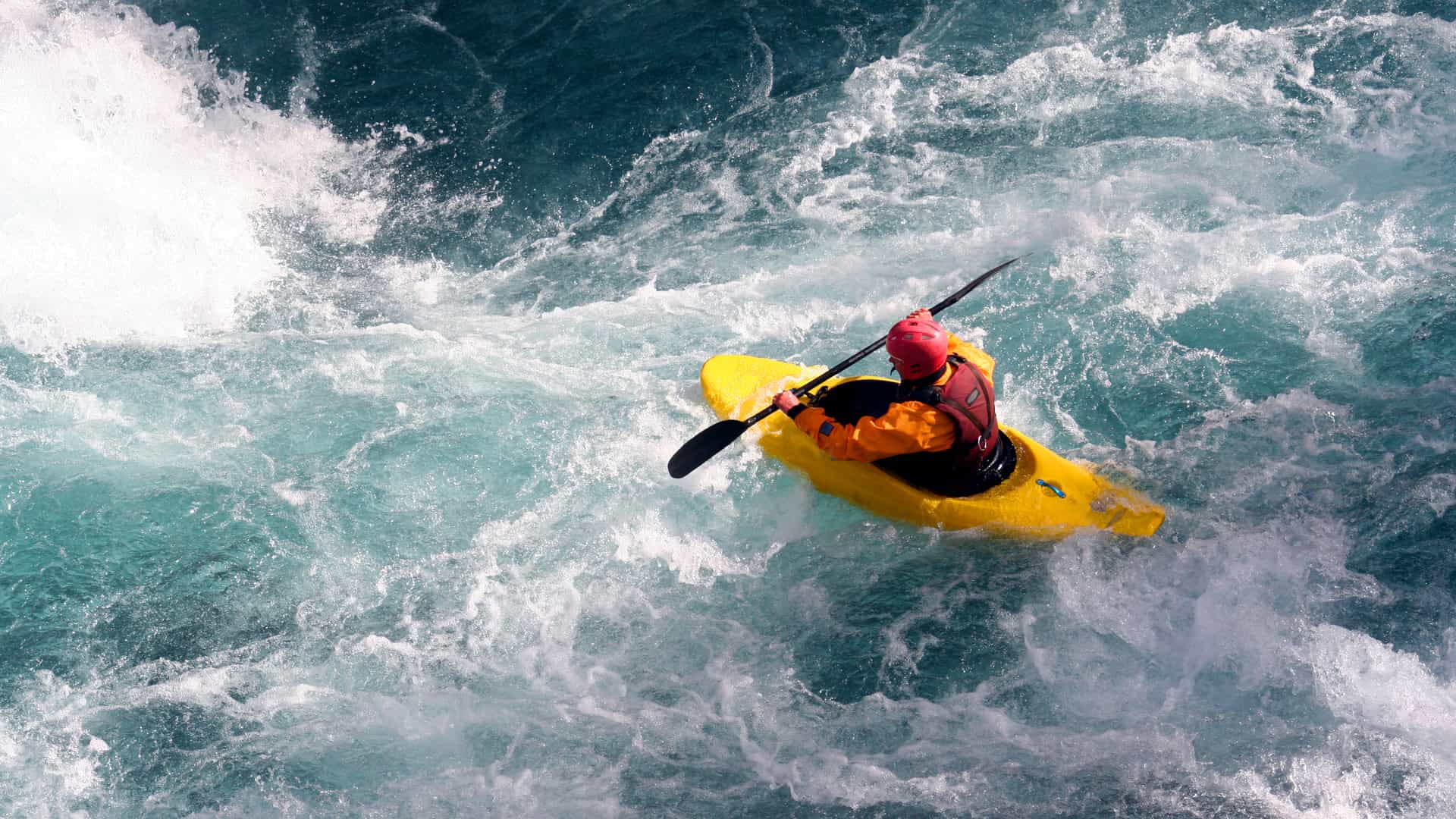 Hombre con kayak por rápidos con seguro de vida hecho con caser