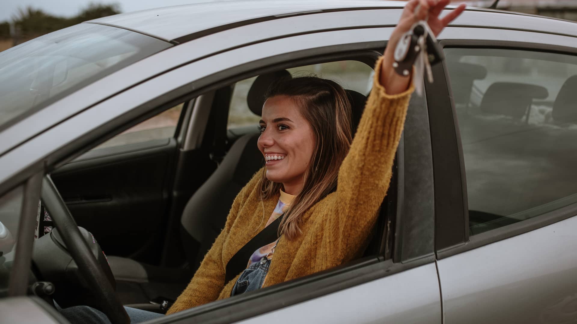 Mujer sonriente en su vehículo asegurado por chapka y con grandes descuentos Mujer sonriente en su vehículo asegurado por chapka y con grandes descuentos