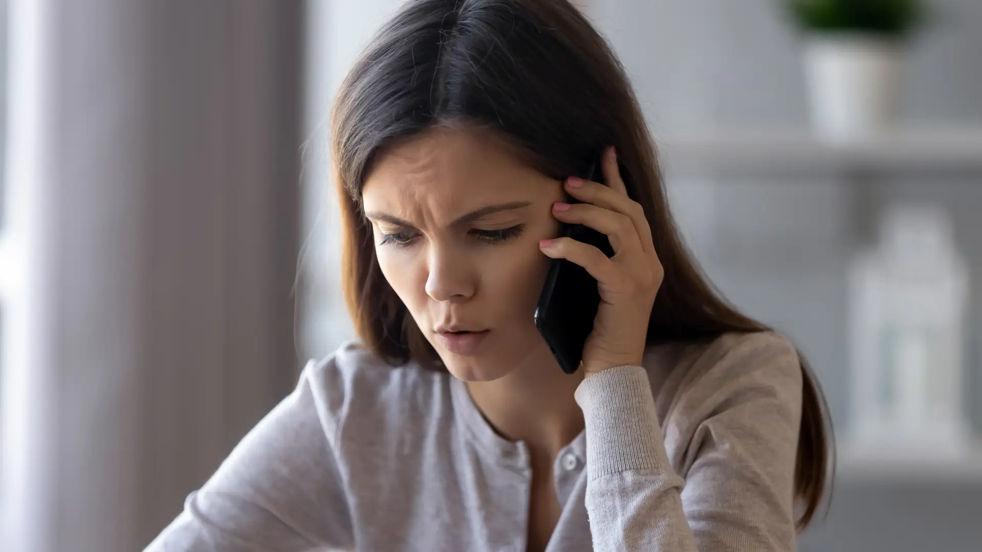 Una chica seria hablando por teléfono para dar de baja sus seguros con Chubb