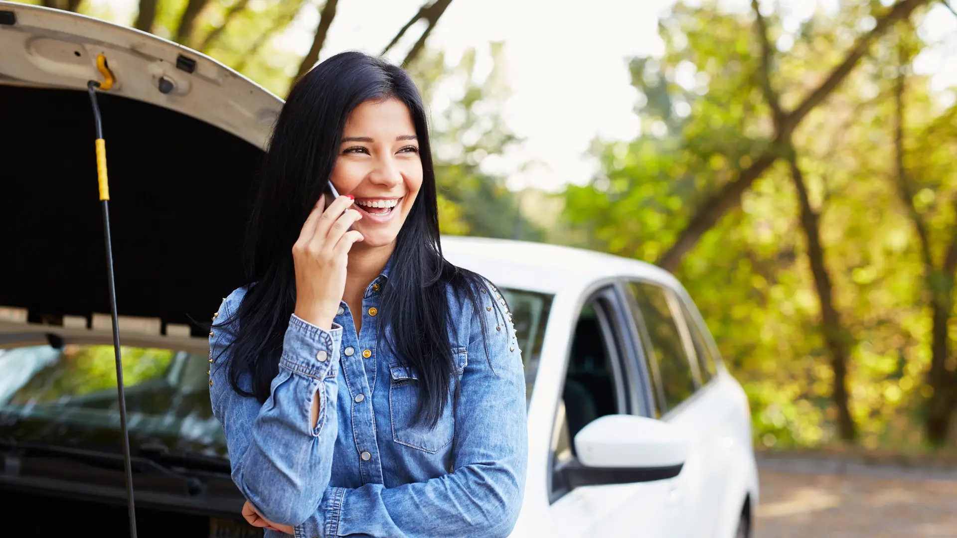Mujer contenta solicitando asistencia en carretera con su seguro de Direct Seguros