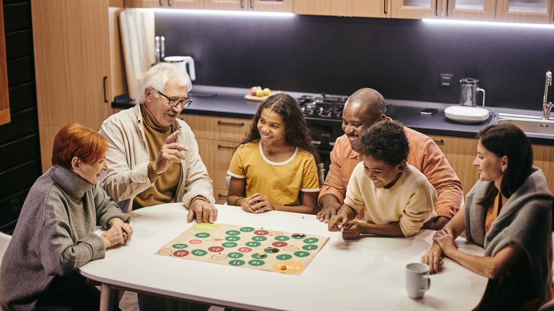 Familia jugando a juegos de mesa en su casa asegurada con direct seguros hogar Familia jugando a juegos de mesa en su casa asegurada con direct seguros hogar