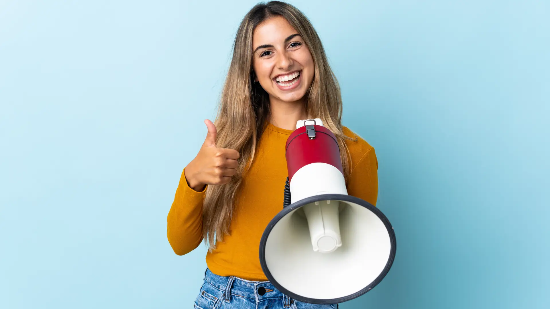 Una chica sujetando un megáfono sobre un fondo azul que representa las opiniones de Europ Assistance