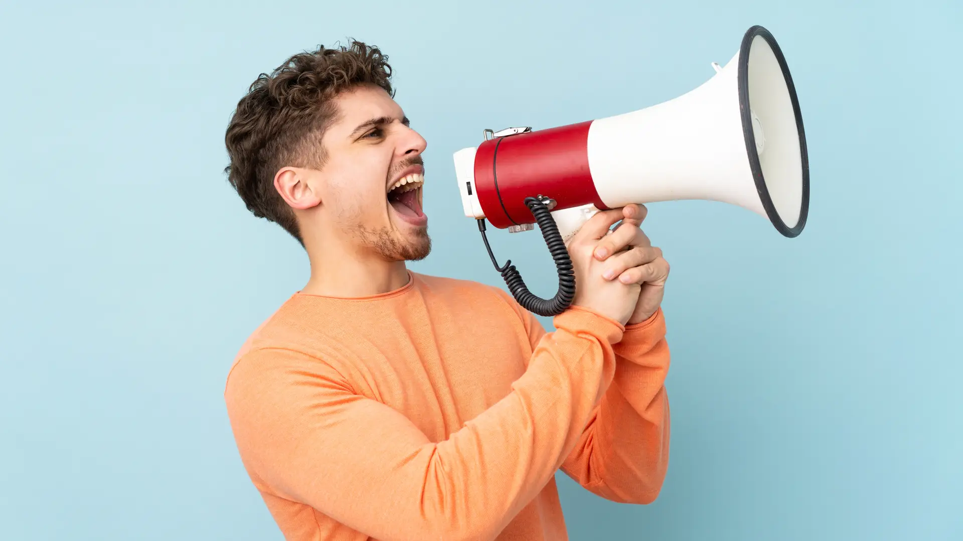 Un chico joven gritando con un megafono que representa las opiniones de la aseguradora Fiatc