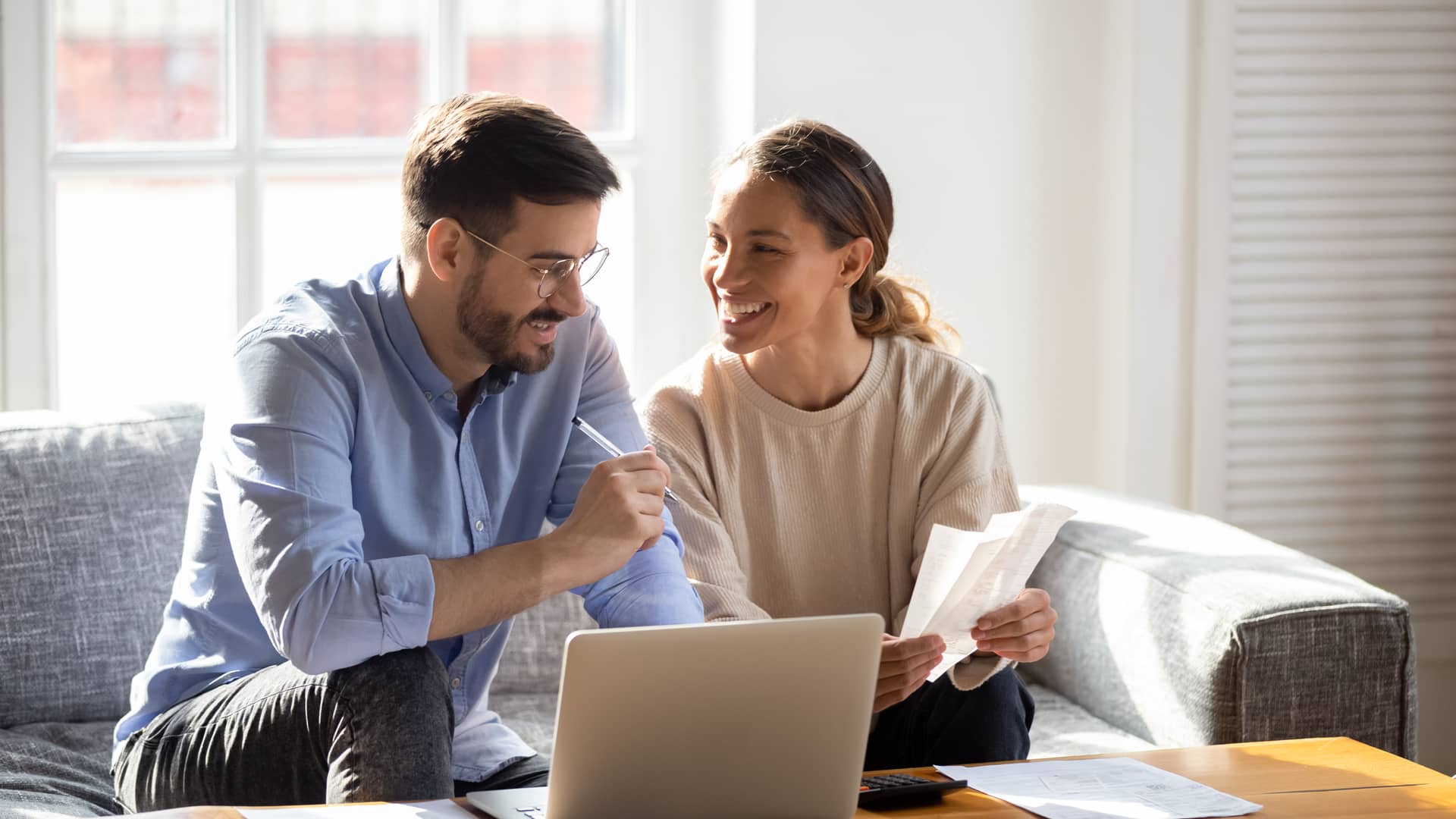matrimonio joven contento revisando los papeles del reembolso de sus seguros con generali matrimonio joven contento revisando los papeles del reembolso de sus seguros con generali