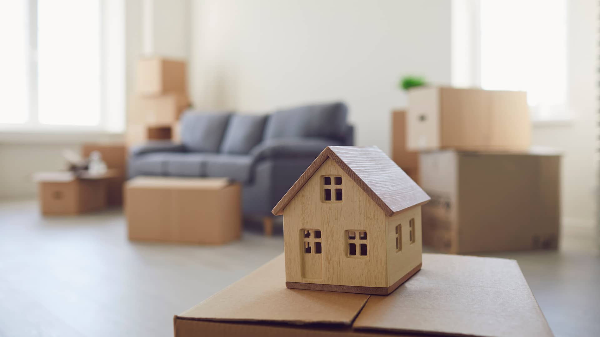 una casita de madera sobre las cajas de una mudanza que representa el seguro de arrendamiento de generali una casita de madera sobre las cajas de una mudanza que representa el seguro de arrendamiento de generali