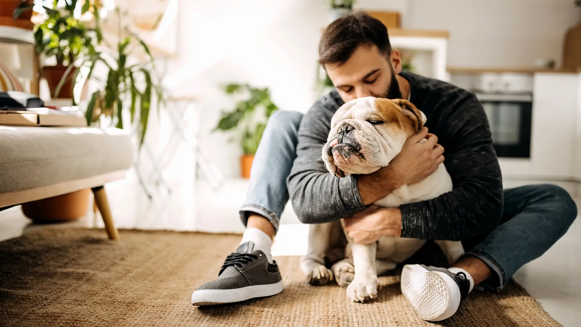 Hombre abrazando a su mascota a la cual tiene hecha un seguro con generali Hombre abrazando a su mascota a la cual tiene hecha un seguro con generali