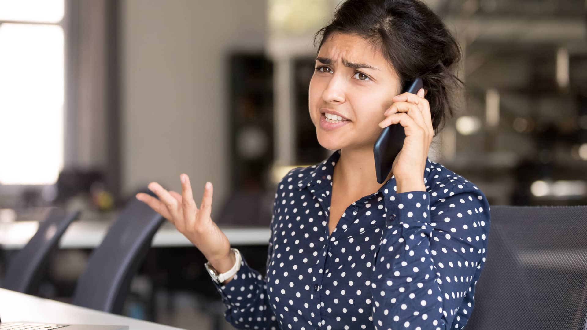 Mujer hablando por teléfono enfadada con teleoperadores de genesis aseguradora para dar de baja sus servicios