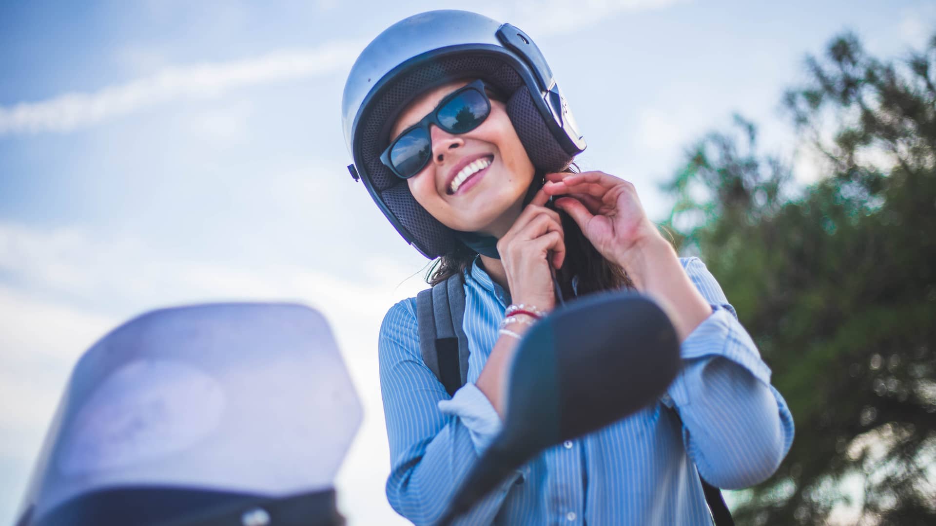Mujer preparandose para conducir su moto asegurada con genesis