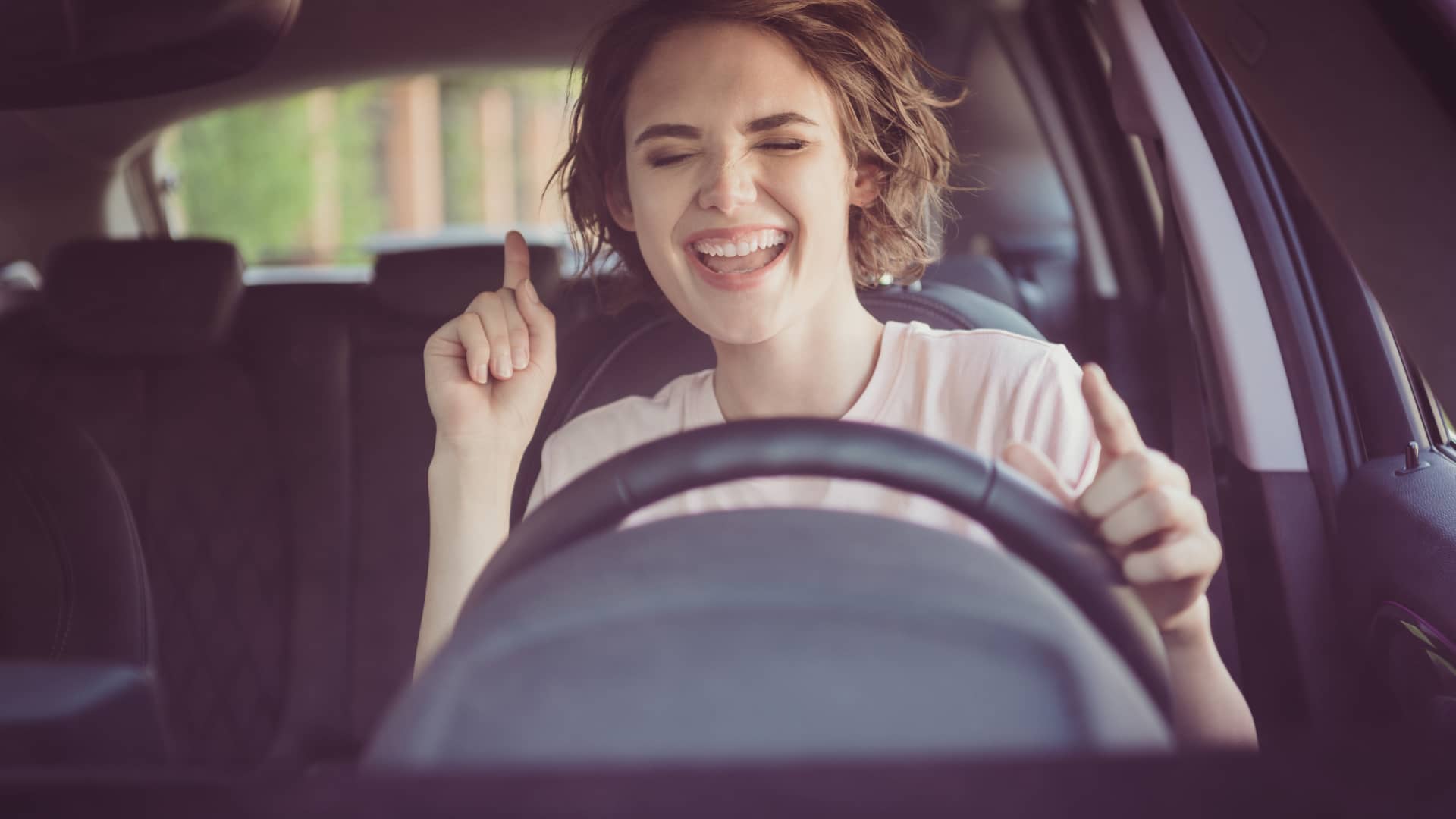 Mujer sonriente conduciendo su coche asegurado en helvetia
